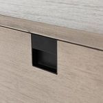 close-up on drawer handle showing rectangular black inset pull and grey washed wood background