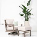Laguna Swivel Club Rocker styled with beige cushions and matching ottoman in white room with potted plant