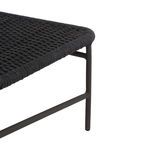 Close-up of woven seat corner and slender metal leg of the dark grey chair