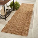 taupe jute rug runner styled on wood flooring next to black metal and wood shelf with decor