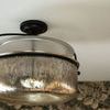 Underside view of semi-flush lantern mounted on ceiling with floral wallpaper background