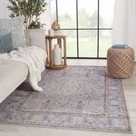 Room setting with the rug laid on light wood floor beside neutral sofa and ottoman