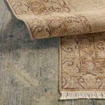 Layered rugs showing contrasting border details and patterns in blue-beige and gold-brown colorways