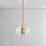 Pendant with bulb lit showing warm glow through clear glass hemispheres against plain white wall