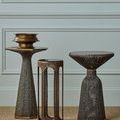 Capella Accent Table grouped with hexagonal and hourglass-shaped metal accent tables in bronze finish