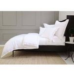 Side view of duvet set showing slightly elevated bed frame and structured headboard in bedroom setting