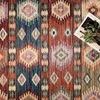 Top-down close-up of Zion Fiesta rug with book and greenery accent showing detailed color variation