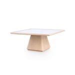 Square light oak wood coffee table with a white rattan inset tabletop and tapered pedestal base