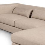 Angled close-up of the sectional seat cushions and lumbar pillows with visible natural beige fabric texture
