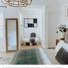Framed artwork hung horizontally on white wall in cozy bedroom with modern decor and wooden floor