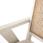 Close-up detail of cream-finished oak armrest and woven cane edge
