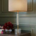 Deville Table Lamp on white background highlighting transparent optic crystal base and antique brass stem