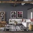 Minimalist vignette with armchairs flanking the rubbed black tripod end table in bright room
