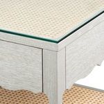 Corner detail of desk showing glass top layer over octagonal cane surface and wood grain texture