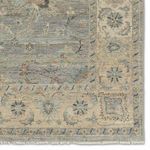 Detailed zoom on border area featuring faded floral medallion motifs and delicate patterning
