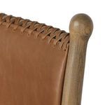 Close-up of woven leather stitching and rounded wooden finial on backrest frame