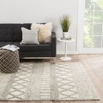 Scandinavian-style living room with rug under modern gray sofa and side table