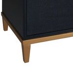 Close-up of tapered gold leaf finished leg and base frame on navy blue media console