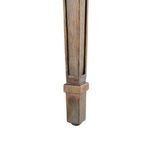 Close-up of tapered wooden leg with carved detailing and subtle distressed finish