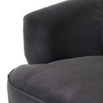 Partial chair view showing seat cushion with fabric folds and piping