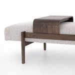 Bench detail angled view emphasizing walnut-toned wood frame and tray with textured fabric seat