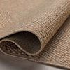 Rolled edge showing rug thickness and polypropylene texture in natural light.