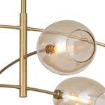 Close-up of two champagne glass globes and natural brass arms highlighting light bulbs and glass texture