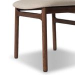 Close-up of front right leg and rounded corner seat edge on Baden Dining Chair with beige upholstery
