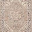 Top-down view centered on the rug’s geometric medallion design with distressed taupe and denim colors