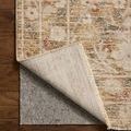 Rug corner flipped up showing thin backing and underside stitching detail on wooden floor