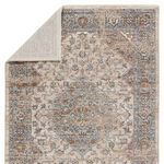 Corner of traditional medallion rug flipped over to reveal light colored backing