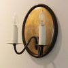 Three-quarter top side view of Ancram Small Double Sconce showing curved arms and candle sleeves