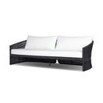 Outdoor sofa shown at a right-side 3/4 angle highlighting curved arms and leg support