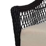 Close-up view of black resin wicker twisting on armrest corner with beige cushion