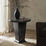 Eslo End Table styled in room setting with dark sofa, light curtains, wood floor, topped with vase and glass