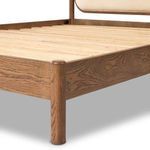Close-up of rounded smoked oak bedpost beside wooden slat base