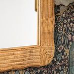 Close-up top right corner view highlighting smooth rattan finish and joint details against wallpaper