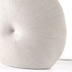 Close-up showing fine linear texture and central dimple on ceramic lamp base