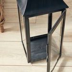 Close-up of lantern corner with open door emphasizing metal frame and glass panel details