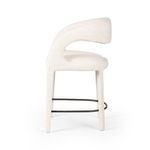 Side profile emphasizing the rounded backrest and slim legs with visible footrest curve.