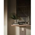 Close-up of Herrero Console central panel with decorative items and geometric wall art in dim light
