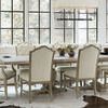 Rustic Patina Side Chairs arranged around a large wood dining table in a bright room with cowhide rugs and large windows