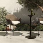 Outdoor setting with two stools beside tall black metal bistro table under tree shade