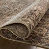Rug partially rolled to reveal tightly woven backing and edge stitching detail
