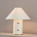 Bond Patina Brass lamp switched on, casting soft warm light on parchment shade and wall