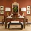 Waterfall Coffee Table styled in a living room with woven chairs, coral wall, and decorative console behind