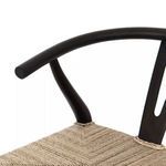 Close-up of smooth curved black teak armrest junction with seat edge