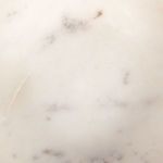 Close-up of marble texture highlighting small gray and brown flecks and smooth finish