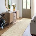 Calla Butter Handmade Rug shown as a long rug runner in a bright entryway between console table and sofa