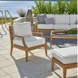 Chesapeake Lounge Chair in outdoor patio scene next to coordinating teak coffee table and ottoman